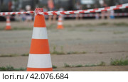 Fencing tape and road cone on the background of passing people. Стоковое видео, видеограф Александр Прошкин / Фотобанк Лори