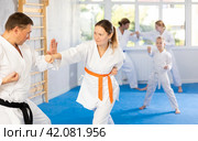 Woman is paired with man teacher to learn how to strike and rehearses blocking opponent. Стоковое фото, фотограф Яков Филимонов / Фотобанк Лори