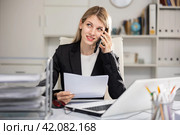 Office woman is discussing the contract by phone in office. Стоковое фото, фотограф Яков Филимонов / Фотобанк Лори