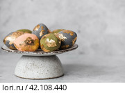 Beautiful Easter eggs with a golden coating were laid on a steel concrete plate on a gray background. The concept of happy Easter 2024. Стоковое фото, фотограф Photojuli / Фотобанк Лори