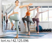 Female yoga practitioner executing one-legged balance with knee hold. Стоковое фото, фотограф Яков Филимонов / Фотобанк Лори