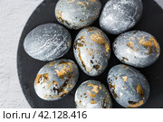Stylish grey Easter eggs made of marble and concrete with a golden potala on a grey background. Coloring eggs with natural dye karkade tea. . The concept of a happy Easter. Стоковое фото, фотограф Photojuli / Фотобанк Лори