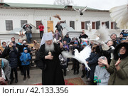 Митрополит Крутицкий и Коломенский Ювеналий перед освящением пасхальных куличей выпустил белых голубей на территории Новодевичьего монастыря Москвы (2018 год). Редакционное фото, фотограф Дмитрий Неумоин / Фотобанк Лори