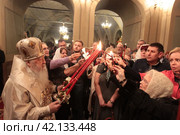 Пасха 2018 года в Успенском храме Новодевичьего монастыря, Москва. Митрополит Ювеналий раздаёт благодатный огонь. Редакционное фото, фотограф Дмитрий Неумоин / Фотобанк Лори