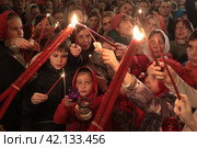 Пасха 2018 года в Успенском храме Новодевичьего монастыря, Москва. Митрополит Ювеналий раздаёт благодатный огонь. Редакционное фото, фотограф Дмитрий Неумоин / Фотобанк Лори