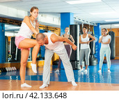 Girl performing knee kick with wristlock to male opponent in sparring. Стоковое фото, фотограф Яков Филимонов / Фотобанк Лори