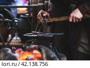 Moscow seasons. A traditional craft. Blacksmith's work with metal. Hammer and anvil. Russian traditions. Moscow. Russia (2023 год). Стоковое фото, фотограф Photojuli / Фотобанк Лори