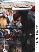 Moscow seasons. A traditional craft. Blacksmith's work with metal. Russian traditions. Hammer and anvil. Moscow. Russia (2023 год). Редакционное фото, фотограф Photojuli / Фотобанк Лори