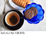 Шоколадное печенье в синей вазочке и чашка чая, вид сверху. Стоковое фото, фотограф Яна Королёва / Фотобанк Лори