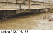 The water in river has risen to the very top of column of bridge. Flooding. Thick large concrete pillars under water. Muddy river after heavy rain. The flow of a dangerous wild river Natural disasters. Стоковое видео, видеограф Воловодов Владимир / Фотобанк Лори
