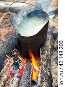 Hiking pots on the fire with a bright flame. Cooking soup in field conditions. Стоковое фото, фотограф Евгений Ткачёв / Фотобанк Лори
