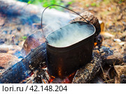 Hiking pots on the fire with a bright flame. Cooking soup in field conditions. Стоковое фото, фотограф Евгений Ткачёв / Фотобанк Лори