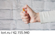 Female hand holding a ballpoint pen. Opens and closes the button. Flick a fountain pen. The gray brick wall Copy space. Стоковое видео, видеограф Глущенко Елена / Фотобанк Лори