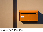 Orange wooden Mailbox in an house residential building outside. Modern numbered mailboxes box outdoors, creative design mail backgrounds. Urban correspondence concept. Copy ad text space. Generated Ai. Стоковое AI-изображение, AI-художник Aleksandr Golubev / Фотобанк Лори