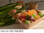 Мармелад фруктовый разноцветный обсыпанный сахаром, тюльпаны, коробочка с подарком в крафтовой коричневой бумаге. Стоковое фото, фотограф Оксана Шведкова / Фотобанк Лори