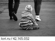 Уставший ребенок сидящий на асфальте и смотрящий вслед уходящих родителей. Стоковое фото, фотограф Валерий Леонидович / Фотобанк Лори