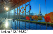 The Olympic rings and the Eiffel tower. Summer Olympic games concept. Стоковое AI-изображение, AI-художник Ирина Михайличенко / Фотобанк Лори