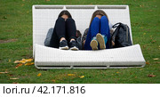 Two young girls students sit in a park on a bench, preparing for outdoor exams. Moscow, Gorky Park. Стоковое фото, фотограф Валерий Леонидович / Фотобанк Лори