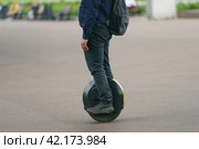 Young man driving Electric unicycle on the Moscow city center. He know how to be fast in the city during coronavirus pandemic time. No traffic. Стоковое фото, фотограф YuryKara / Фотобанк Лори