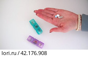 Close up of female hands pours pill from daily box. Colorful pills containers on a white background. Morning, day, evening. Daily take a medicine, tablets, drugs. Multi Colored Weekly Pill Organizer. Стоковое видео, видеограф Марина Демидюк / Фотобанк Лори