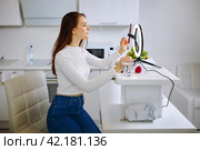 Beauty blogger uses ring light with cell phone holder during live stream at home. Стоковое фото, фотограф Владимир Григорьев / Фотобанк Лори