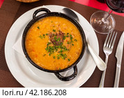There is traditional Spanish dish on table - Fabada Asturian decorated with chopped green onions. Стоковое фото, фотограф Яков Филимонов / Фотобанк Лори