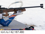 Sportswoman biathlete rifle shooting in prone position. Selective focus, extreme close-up shot. Biathlete in shooting range (2019 год). Редакционное фото, фотограф А. А. Пирагис / Фотобанк Лори