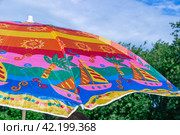 Зонт от солнца для пляжного отдыха. Разноцветный пляжный зонт для защиты от солнечных лучей. Парасоль - это зонт, предназначенный для защиты от солнца. Стоковое фото, фотограф Эдуард Белкин / Фотобанк Лори