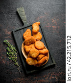 Chicken nuggets in a bowl on a cutting Board with thyme. Стоковое фото, фотограф Артем Шадрин / Фотобанк Лори