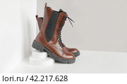 Brown shoes. Trendy Boots Pair on white and gray Background. Copy space, top, side view. Shoe sale, fashion concept. Stylish Casual shoes for city. Overhead shot of chelsea boots. Urban lifestyle. Стоковое фото, фотограф Марина Демидюк / Фотобанк Лори