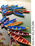 Multi-colored wooden boats on the Phewa lake, Pokhara, Nepal (2015 год). Стоковое фото, фотограф VittoriaChe / Фотобанк Лори