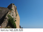 Citadel Budva, Old Town on sunny day, Montenegro. Stone walls. Blue sky. Fortifications of Budva are typical of the Medieval cities of Adriatic towers, embrasures, fortified city gates and a citadel. (2022 год). Стоковое фото, фотограф Юлия Петровская / Фотобанк Лори