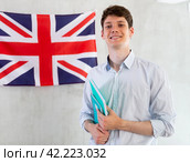 Young guy posing with notebooks against background of UK flag. Стоковое фото, фотограф Татьяна Яцевич / Фотобанк Лори