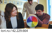 Students in physics class spin Newton's multicolored disk. Стоковое фото, фотограф Mikhail Davidovich / Фотобанк Лори