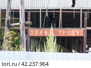 Россия, Тверская область, поселок городского типа Селижарово. Старая вывеска "Слава труду" на разрушенном здании. Russia, Tver region, Selizharovo urban-type settlement. The old sign "Glory to labor" on the destroyed building. (2020 год). Стоковое фото, фотограф Мария / Фотобанк Лори