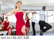 Woman in red dress practicing playful jitterbug in dance studio. Стоковое фото, фотограф Яков Филимонов / Фотобанк Лори