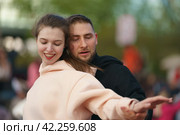 Moscow, Russia - May 9, 2022: Cheerful Dancing couple of young man and woman in public park. Lifestyle theme. Having fun people. People celevrate Victory Day, the win in the Great Patriotic War. Редакционное фото, фотограф YuryKara / Фотобанк Лори