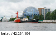 Kaliningrad, Russia - June 21, 2022:   Museum of the World Ocean. Building is in form of glass ball. Irbensky floating lighthouse. Moored on Pregolya River. SRT-129 is medium fishing trawler. Редакционное фото, фотограф YuryKara / Фотобанк Лори