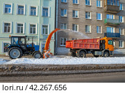 Трактор МТЗ-82.1 с навесным снегоуборщиком чистит от снега тротуар городской улицы. Кронштадт (2022 год). Редакционное фото, фотограф Виктор Карасев / Фотобанк Лори