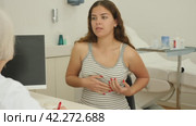 Positive young woman patient viewing silicone for mammoplasty during consultation with specialist in aesthetic clinic. Стоковое видео, видеограф Яков Филимонов / Фотобанк Лори