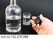 Бутылка и рюмка с алкоголем и рука с ключом от автомашины. Стоковое фото, фотограф Анна Аникова / Фотобанк Лори