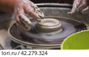 A woman potter working on a potter's wheel, making a ceramic pot out of clay in a pottery workshop. Traditional Arabian art concept, creative workshop and masterclass. Стоковое видео, видеограф Воловодов Владимир / Фотобанк Лори