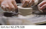 A potter working on a potter's wheel, making a ceramic pot out of clay in a pottery workshop. Traditional Arabic art concept, creative workshop and masterclass. Стоковое видео, видеограф Воловодов Владимир / Фотобанк Лори