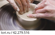 A woman's hands create a clay pot on a pottery wheel. Pottery. A girl engaged in pottery, handicraft, working with clay. Close up. Slow motion. Стоковое видео, видеограф Воловодов Владимир / Фотобанк Лори
