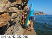 Budva, Montenegro, Mogren beach 8.15.22 Flysch is a series of marine sedimentary rocks. Alternation of lithological layers. Balkans, Adriatic Sea, Mediterranean. People tourists come from the beach (2022 год). Редакционное фото, фотограф Юлия Петровская / Фотобанк Лори
