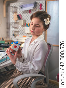 Ekaterinburg, Russia, February 14 2024: Cute girl at home solving a rubik's cube. It was invented by Hungarian architect Erno Rubik in 1974. Редакционное фото, фотограф Ольга Ильина / Фотобанк Лори