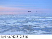 Доставка грузов и снабжение в Арктике. Морской арктический пейзаж с грузовым судном в море среди льдин. Морские грузоперевозки в сложной ледовой обстановке. Июнь на Крайнем Севере России. Анадырский залив, Берингово море, Тихий океан. Чукотка, Дальний Восток России. Стоковое фото, фотограф Андрей Степанов / Фотобанк Лори
