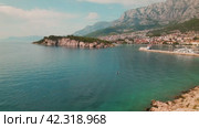 Adriatic Coastal town in Croatia. Makarska Riviera basks in sunlight with the Adriatic's blue sea complementing Biokovo mountain. Стоковое видео, видеограф Igor Tichonow / Фотобанк Лори