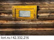 Небольшое окно в деревянной стене. Вид на маленькое окно с желтой рамой. Деревянное здание бани в деревне. Стоковое фото, фотограф Андрей Степанов / Фотобанк Лори