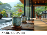 Chinese Ceremony. Brown ceramic pot and brown cup .Green tea on bamboo mat, aged wooden table. Japanese Tea - Hot Teapot And Teacups On Bamboo Mat. Стоковое AI-изображение, AI-художник Ирина Михайличенко / Фотобанк Лори